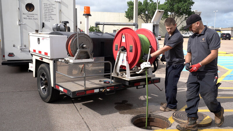 plumbers performing hydrojetting service in a sewer drain