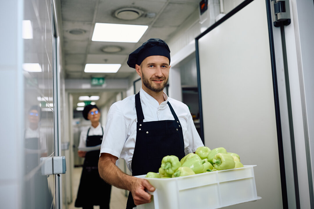restaurant worker moving fresh produce into the cooler