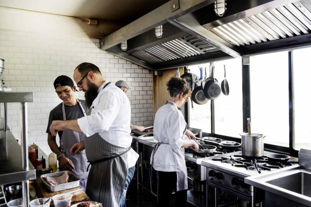 restaurant chefs prepping food in commercial kitchen