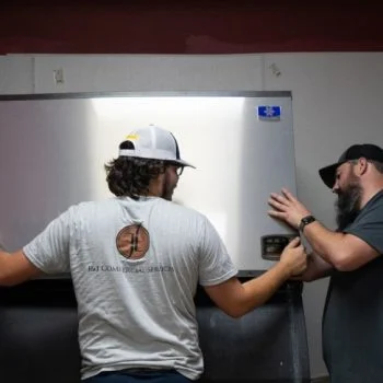 J&J Commercial Services team members repair refrigerator